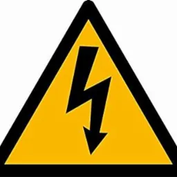 Żółty trójkątny znak ostrzegawczy z czarną obwódką i symbolem czarnej błyskawicy wskazującej w dół, oznaczający niebezpieczeństwo porażenia prądem elektrycznym.