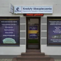 Fasada budynku Centrum Kredytów i Ubezpieczeń Domena z ofertami widocznymi na szybach: kredyty gotówkowe, hipoteczne, pożyczki, ubezpieczenia OC/AC/NNW oraz pomoc w rejestracji pojazdów.