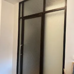 Szklane drzwi z brązową ramą i ozdobną fakturą szkła, zamontowane w Krzywdzie. Minimalistyczny design i dyskretne wykończenie.