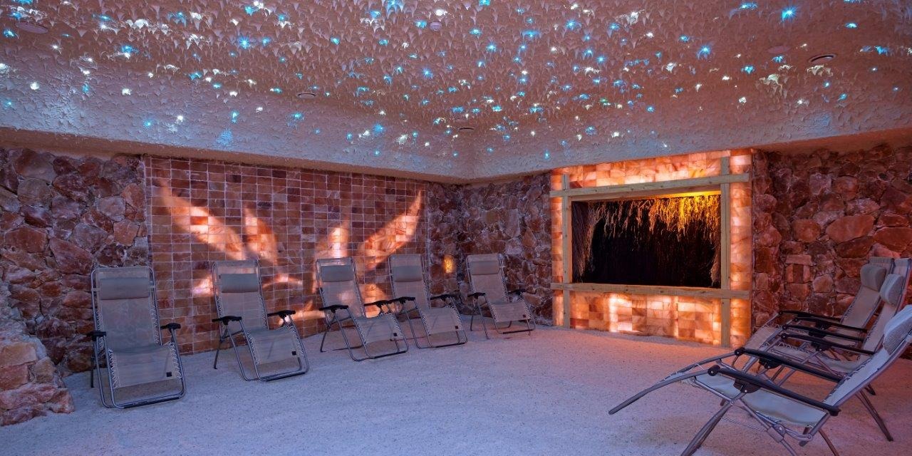 Wnętrze sauny solnej z leżakami, ścianami z cegieł solnych i sufitem z imitacją gwiazd.