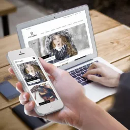 Osoba przegląda responsywny układ sklepu internetowego 'MAX-Leather' na laptopie i smartfonie, widoczny interfejs użytkownika z kategoriami produkt&oacute;w i zdjęciem modelki w zimowej scenerii.