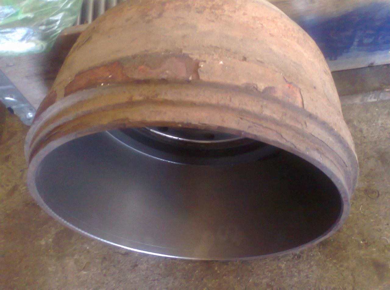 Wnętrze metalowego cylindra z widocznymi śladami korozji na zewnętrznej, grubszej obudowie. Wnętrze cylindra jest gładkie i metalicznie błyszczące.