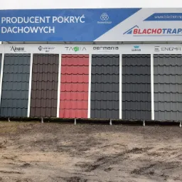 Ekspozycja różnych modeli i kolorów pokryć dachowych, w tym czerwonych i grafitowych, prezentowana na zewnątrz z widocznym logo Blachotrapez i Thyssenkrupp na górnym banerze.