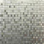 Abstrakcyjna mozaika złożona z małych, kwadratowych płytek w odcieniach szarości i srebra, tworząca efekt trójwymiarowości dzięki różnicom w odbiciu światła.