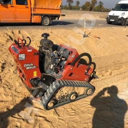 HELL-BUD Heleniak Adrian - Pomarańczowa koparka łańcuchowa Ditch Witch 30 na piasku z widocznym numerem telefonu, w tle pomarańczowy samochód dostawczy i biały bus