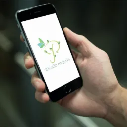 Smartfon w dłoni wyświetlający logo aplikacji z motywem roślinnym i napisem 'sposób na życie'.