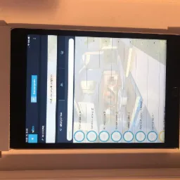 Tablet z uruchomioną aplikacją do sterowania oświetleniem w inteligentnym domu, widoczne ustawienia dla różnych stref i lamp w domu.