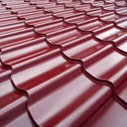 Błyszczące, bordowe elementy metalowego poszycia dachowego o falistym kształcie, ułożone równolegle i nachylone w kierunku obserwatora.