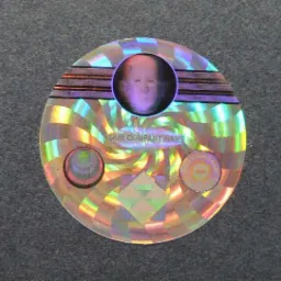 Okrągła, holograficzna nalepka z miejscem na logo firmy i tekst, na szarym tle.