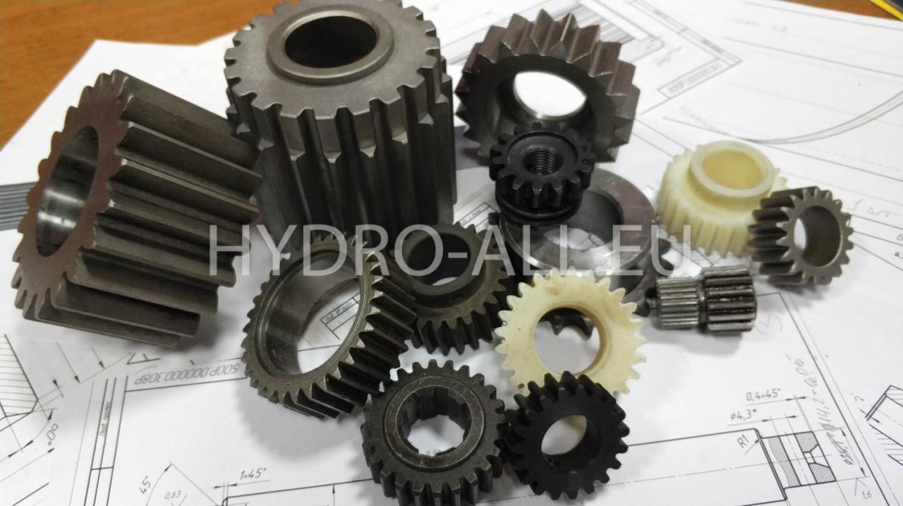 Zestaw różnych rozmiarów i materiałów kół zębatych na tle rysunku technicznego, ukazujący precyzję wykonania i różnorodność produkcji.