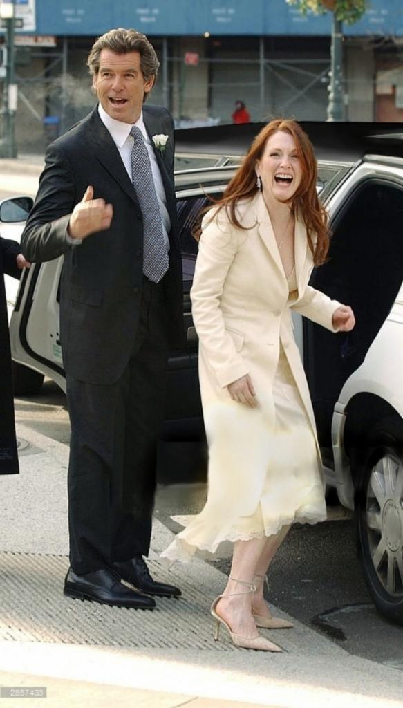 Uśmiechnięty mężczyzna w czarnym garniturze z butonierką i kobieta w jasnym płaszczu wysiadają z białej limuzyny na tle miejskiej ulicy.