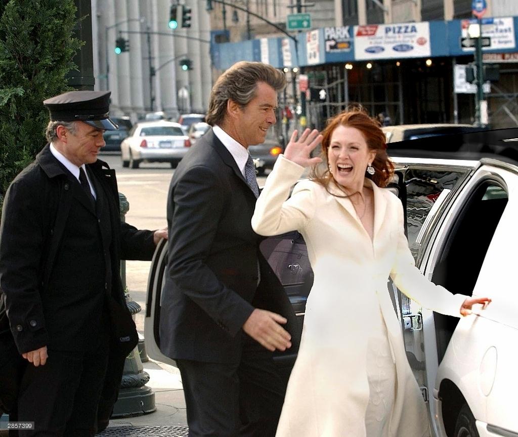 Uśmiechnięta kobieta w jasnym płaszczu wychodzi z białej limuzyny, pozdrawiana przez kierowcę w uniformie i mężczyznę w garniturze na tle miejskiego krajobrazu z sygnalizacją świetlną i reklamami.