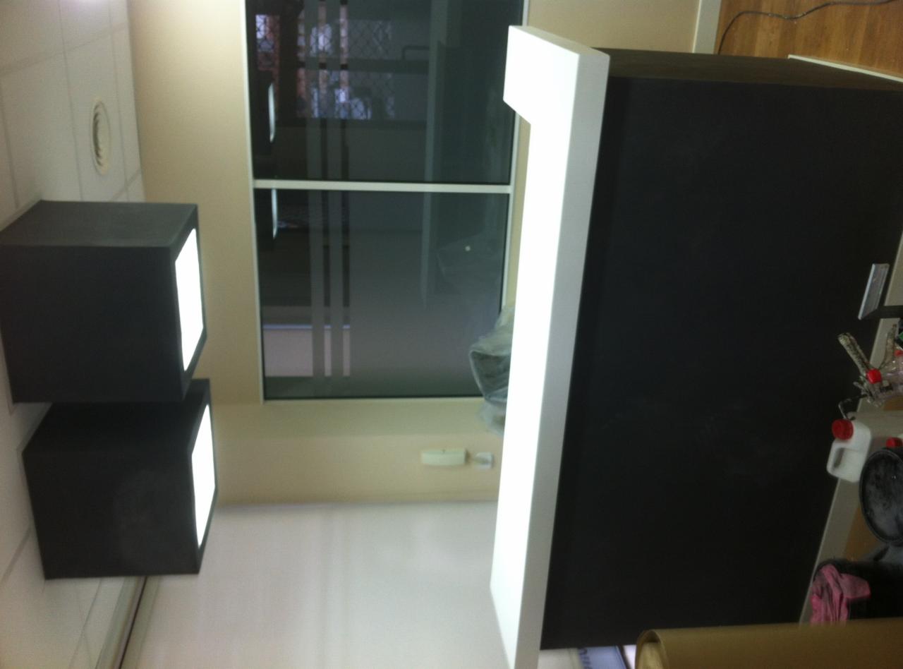 Czarne, podświetlane kostki na suficie, widok na okno i fragment czarnej szafki z białym obramowaniem, ujęcie z dołu.