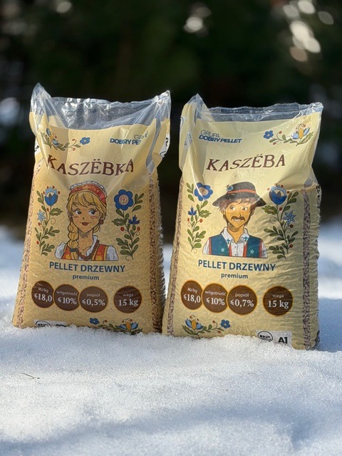 Dwa worki pelletu drzewnego Kaszëba premium na śniegu. Na workach grafika z motywami kaszubskimi i informacjami o parametrach produktu.