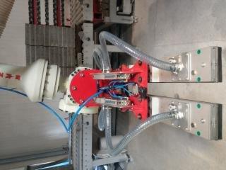 Czerwony, automatyczny rozdzielacz przewodów elektrycznych z podłączonymi kablami i rurami, prawdopodobnie w trakcie instalacji w Pilznie.