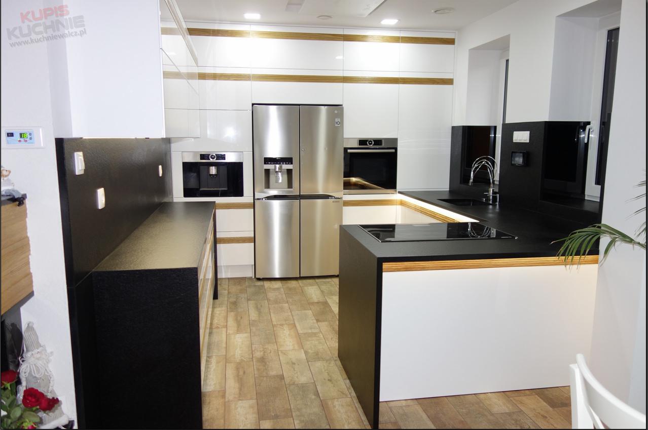 Nowoczesna kuchnia: białe lakierowane fronty szafek z poziomymi wstawkami imitującymi drewno, czarne blaty, srebrna lodówka side-by-side, wbudowany ekspres do kawy i piekarnik, oświetlenie LED...