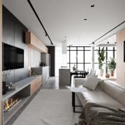 Przestronne, nowoczesne wnętrze apartamentu z otwartą kuchnią, marmurową wyspą i kominkiem pod telewizorem, oświetlone punktowymi lampami na szynoprzewodzie.