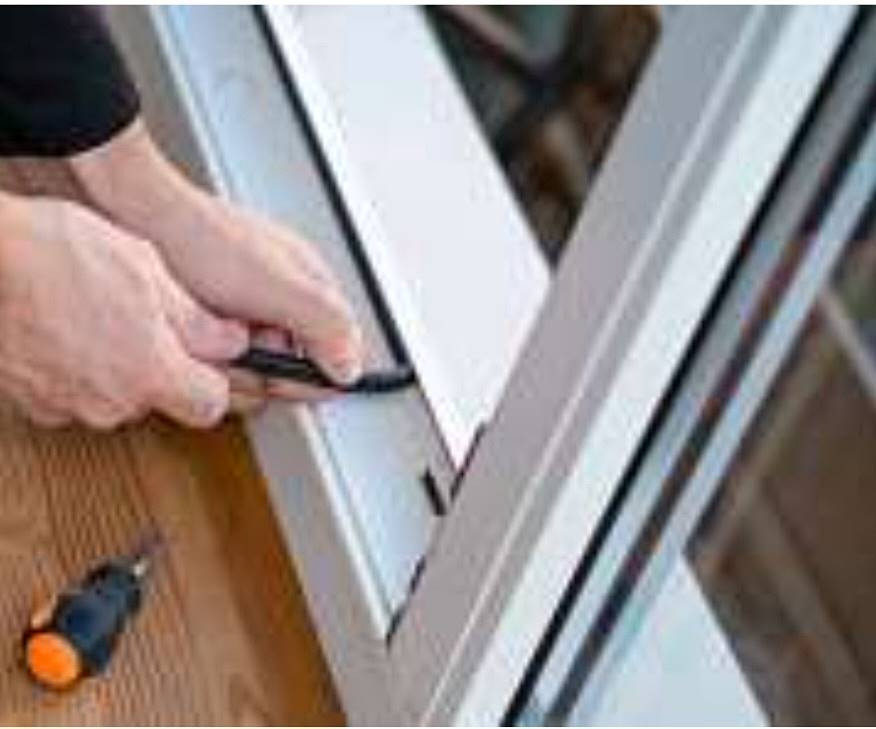 Ręce instalują uszczelkę w ramie okiennej z PCV, obok leży śrubokręt z pomarańczową rączką.