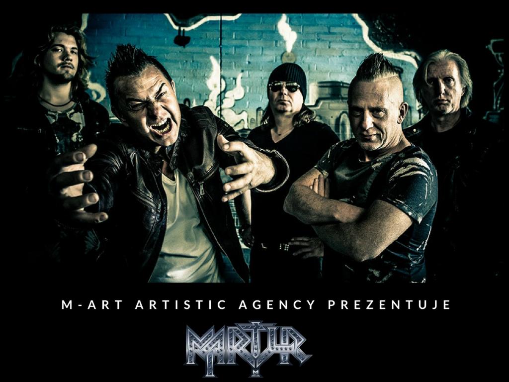 Mroczny portret pięciu mężczyzn z ekspresją, w tym wokalista z wyciągniętymi rękami, na tle ściany z graffiti, z logo i napisem 'M-ART ARTISTIC AGENCY PREZENTUJE' na dole.