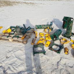 Sabbia Zabezpoeczenia Antykorozykne - Elementy metalowe konstrukcji placu zabaw, częściowo pomalowane na żółto i zielono, rozłożone na piasku i palecie, prawdopodobnie po usunięciu starej powłoki.