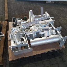 Sabbia Zabezpoeczenia Antykorozykne - Metalowe elementy konstrukcyjne po obróbce, ułożone na palecie z drewna. Widoczne ślady po procesie obróbki, jasnoszary kolor metalu.