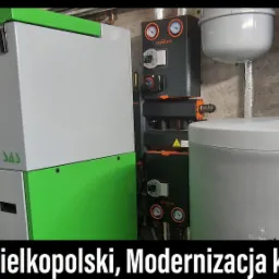 Nowoczesna kotłownia z kotłem na paliwo stałe SAS w kolorze szaro-zielonym, zestawem Termojet z manometrami i zbiornikami wyrównawczymi w kolorach szarym i niebieskim.