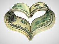 Stos banknotów dolarowych ułożonych w kształt serca na jasnym tle.