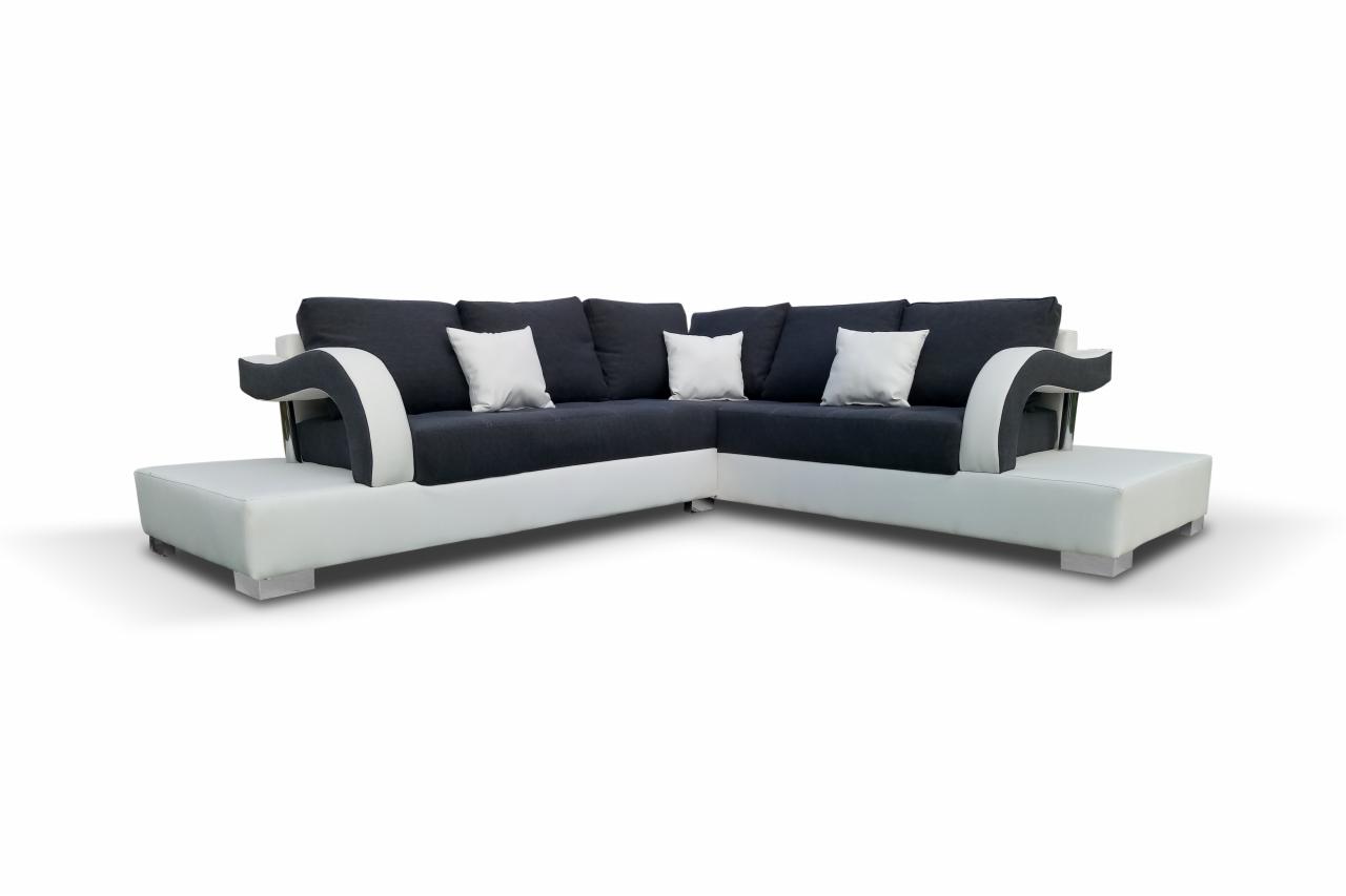 Nowoczesny narożnik tapicerowany w bieli i granacie z poduszkami, charakterystyczne zaokrąglone podłokietniki z białymi wstawkami, widoczne niskie, srebrne nóżki.