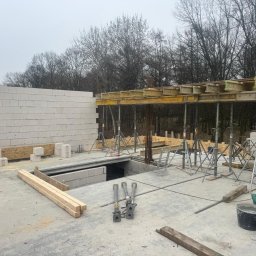 Solutionis Marek Skałbania - Budowa domu w trakcie: ściana z bloczków, szalunki stropowe na podporach, widoczne zbrojenia. Surowy stan, przygotowania do dalszych prac konstrukcyjnych.