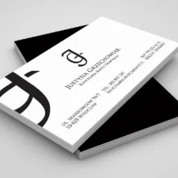 Stos wizytówek z danymi kontaktowymi kancelarii radcy prawnego Justyny Grzechowiak, zawierających logo, adres we Wrocławiu, numer telefonu i adres e-mail.