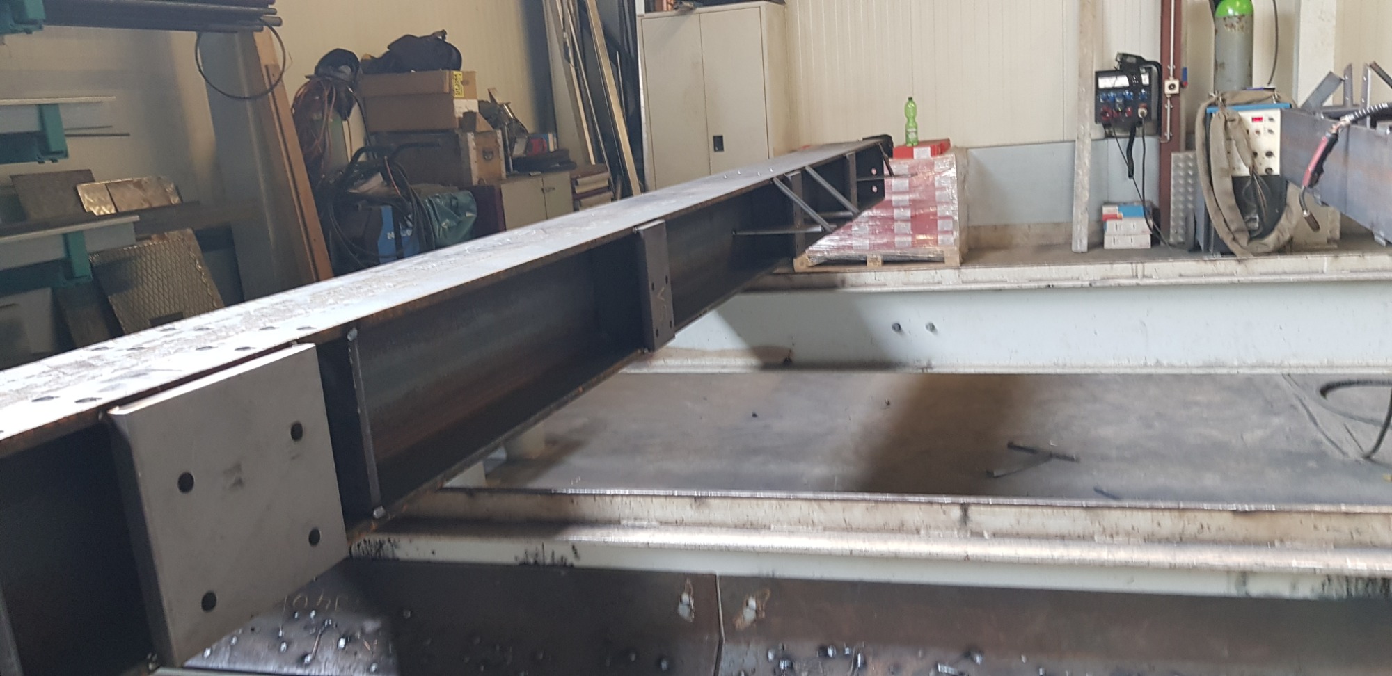 Element konstrukcji stalowej, spawany profil zamknięty z płytą czołową z otworami, widoczne ślady spawania i otoczenie warsztatowe.