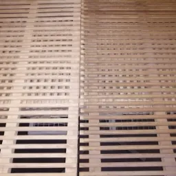 Drewniana krata, połowa oczyszczona, połowa z widocznym starym wykończeniem, ukazująca różnicę w wyglądzie przed i po obróbce.