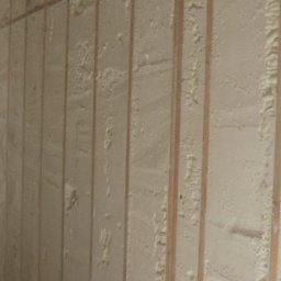 SCANDIPUR SPÓŁKA Z OGRANICZONĄ ODPOWIEDZIALNOŚCIĄ - Ściana szkieletowa wypełniona pianką izolacyjną PUR, widoczne drewniane słupki i instalacja elektryczna w ścianie.