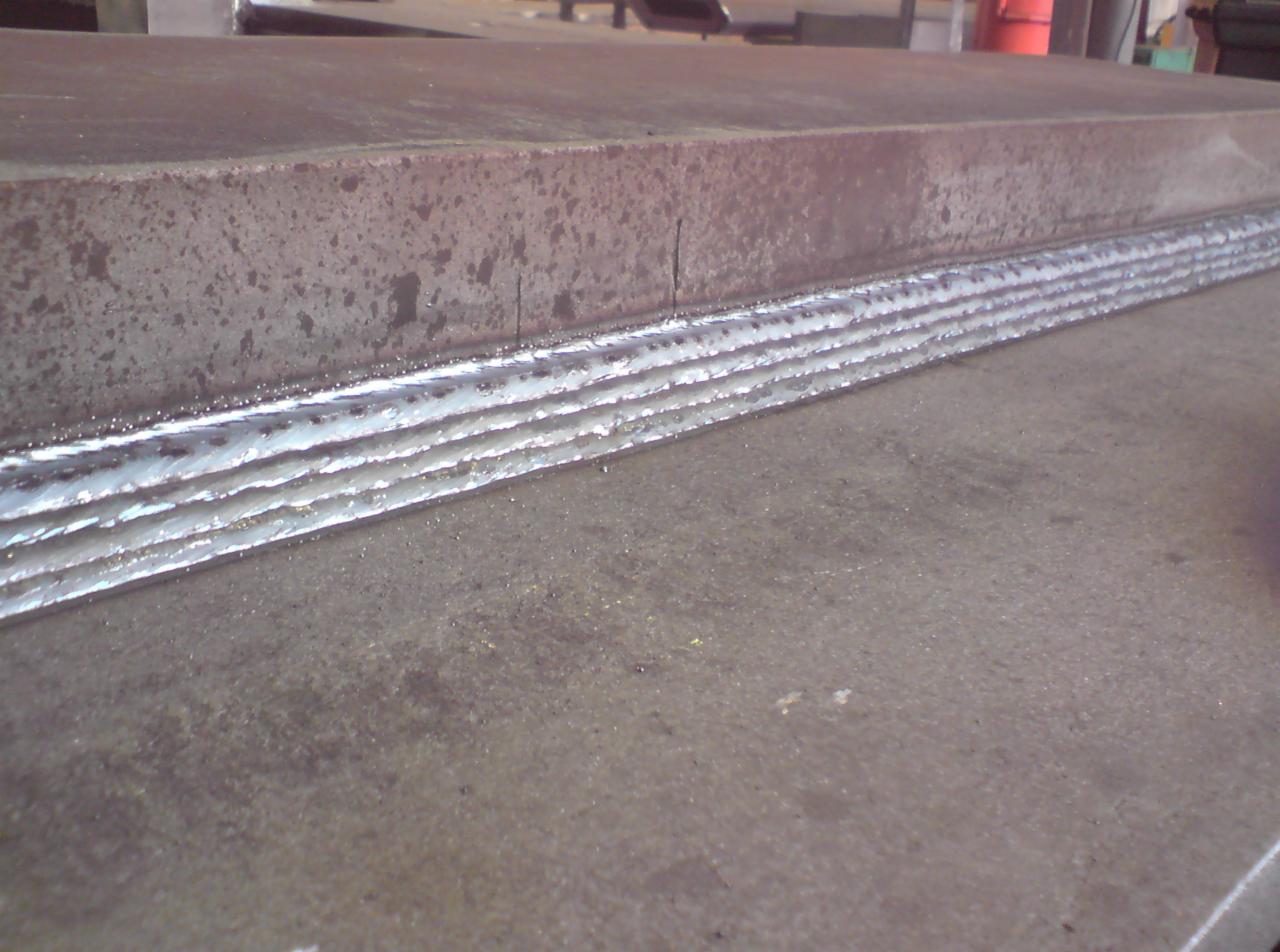 Wielowarstwowa spoina na grubym elemencie stalowym, wykonana w Karlino, widoczne drobne odpryski metalu.