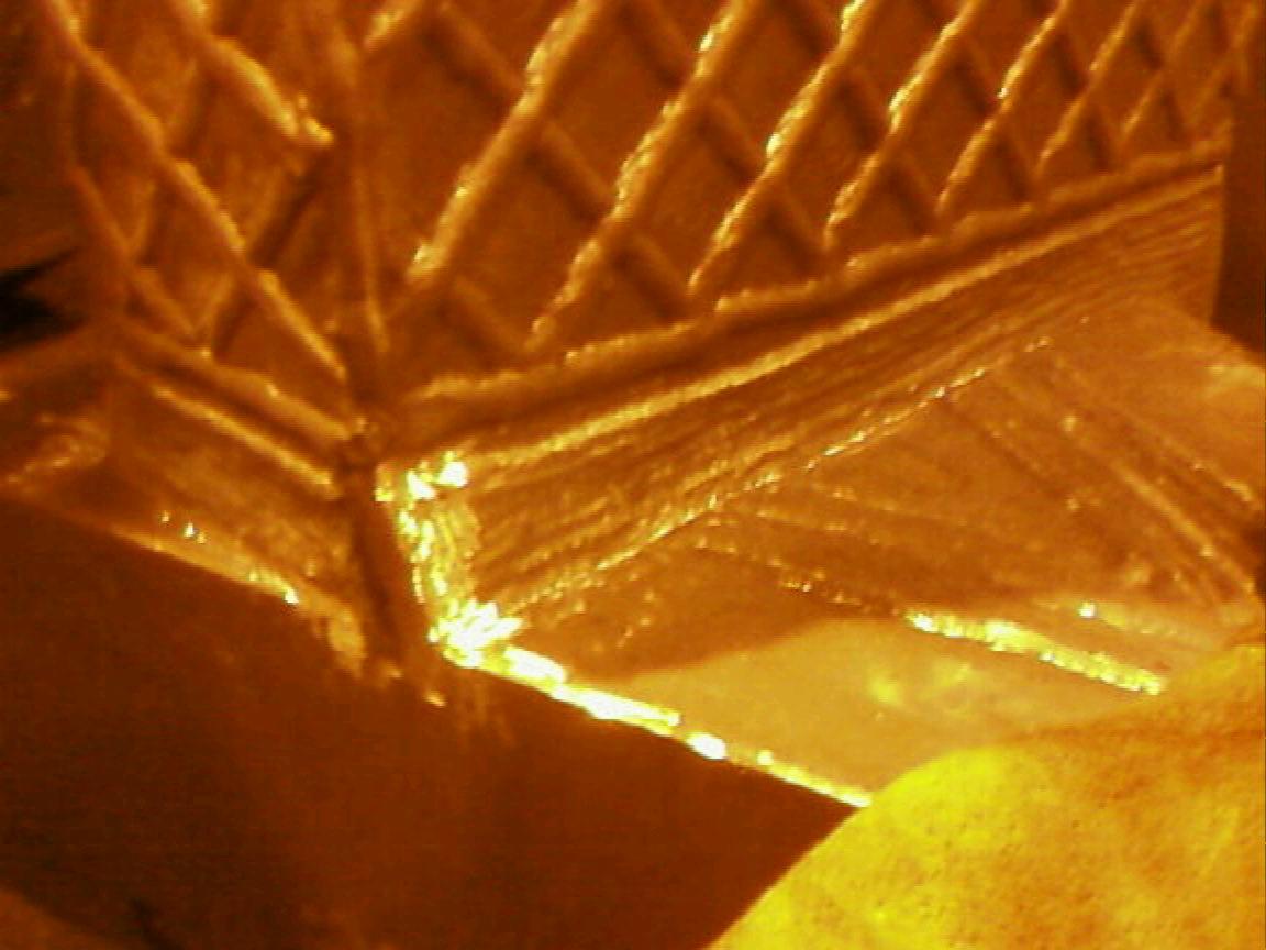 Detalik konstrukcyjny z metalu w ciepłym świetle, widoczny spaw na łączeniu elementów kratownicy.