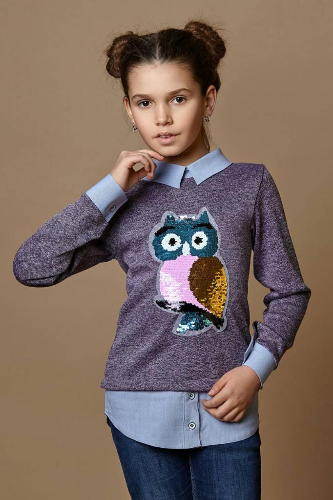 Dziewczynka w fioletowej bluzce z aplikacją sowy z cekinów, ubrana na koszulę z kołnierzykiem, na beżowym tle.