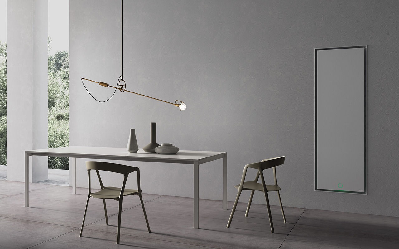 Minimalistyczna jadalnia z grzejnikiem panelowym na ścianie, nowoczesnym oświetleniem i białym stołem z krzesłami w odcieniach szarości.