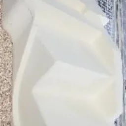 Biały, przestrzenny model architektoniczny antresoli, wydrukowany w 3D, leżący na jasnym, wzorzystym podłożu.