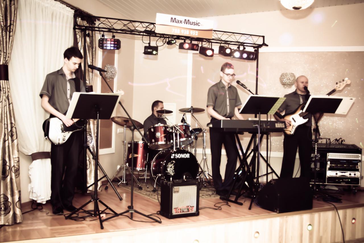 Czteroosobowy zespół na scenie z instrumentami: perkusja Sonor, gitara, bas i keyboard Korg, oświetlenie sceniczne oraz transparent z nazwą 'Max-Music' i numerem telefonu.