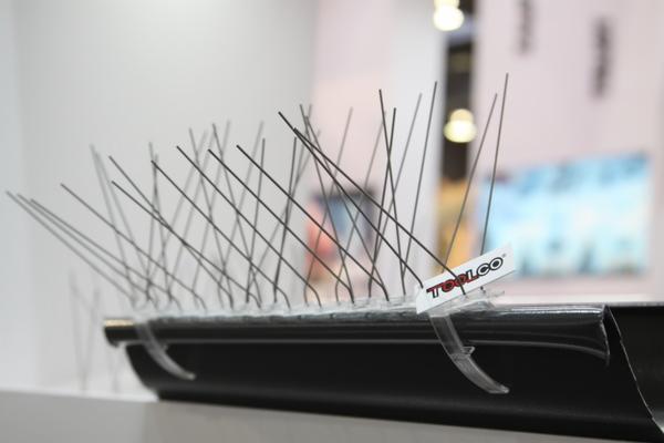 Metalowe kolce na plastikowej listwie zamontowane na krawędzi rynny, zabezpieczenie przed ptakami, z widocznym logo producenta Toolco.