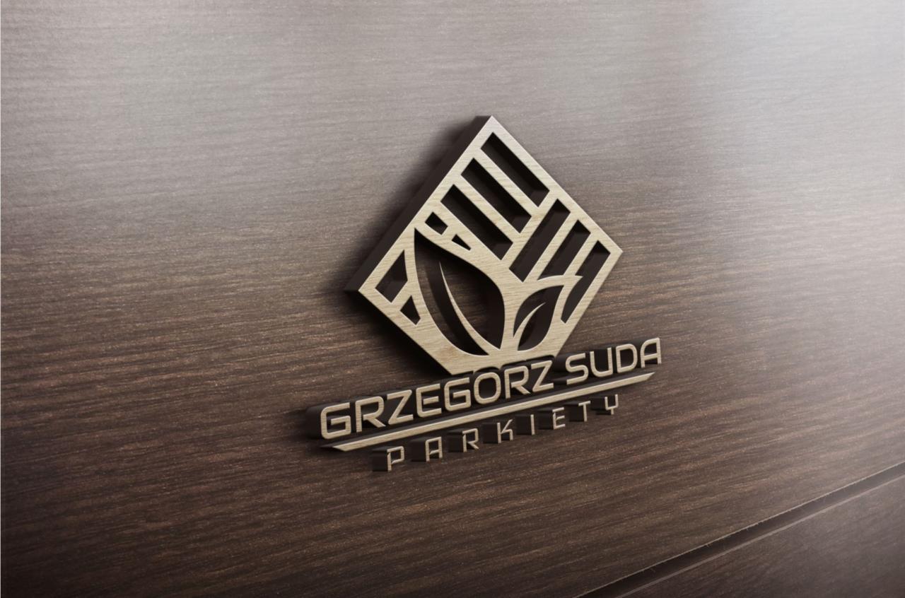 Drewniane logo firmy parkieciarskiej 'Grzegorz Suda Parkiety' na tle paneli ściennych imitujących drewno.