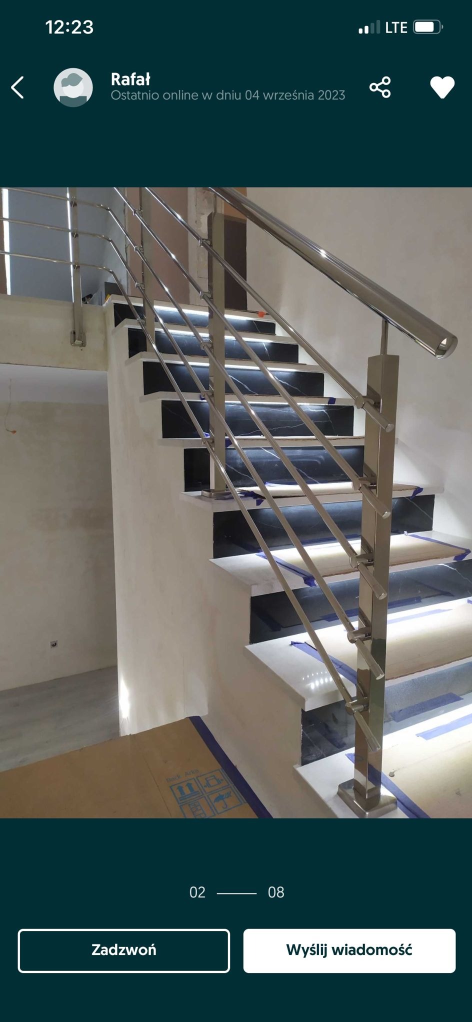 Polerowane, metalowe poręcze schodowe z poziomymi prętami, zamontowane na schodach z czarnymi i białymi płytkami. Widoczne zabezpieczenia na schodach.