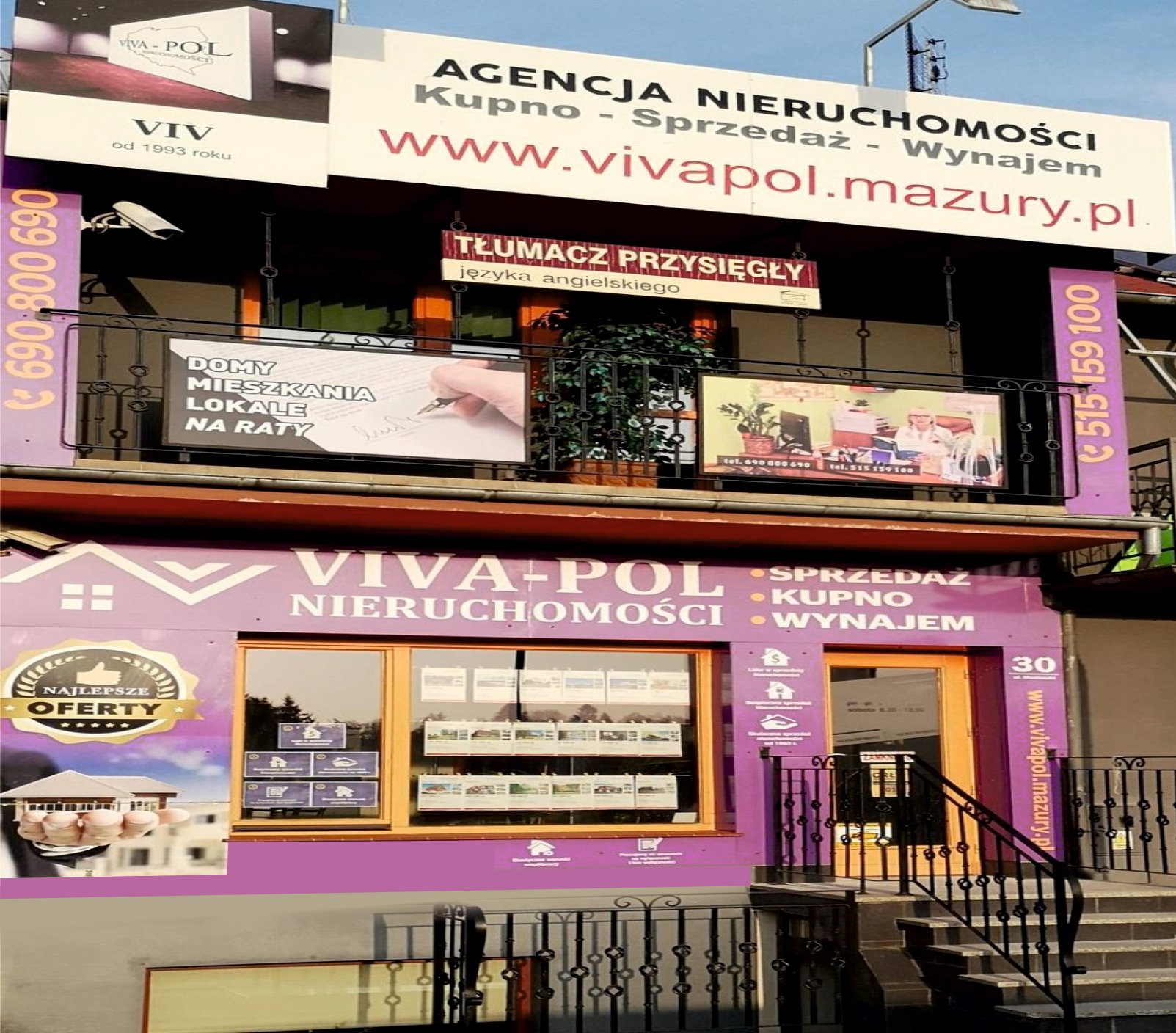 Fioletowa fasada agencji nieruchomości Viva-Pol z szyldami reklamowymi, w oknach oferty nieruchomości oraz numer telefonu kontaktowy.