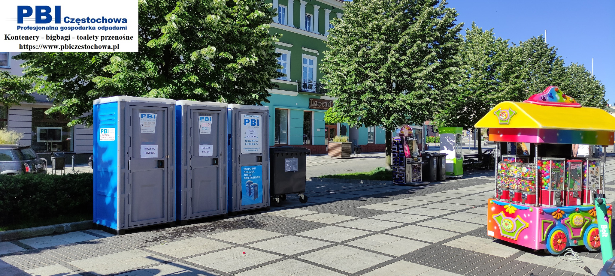 Trzy przenośne toalety ustawione na placu miejskim, z widocznymi oznaczeniami 'Toaleta Damska' i 'Toaleta Męska' oraz logo firmy PBI Częstochowa, w tle budynki i drzewa.