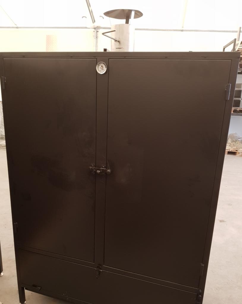 Czarna, metalowa szafa z dwiema parami drzwi, wyposażona w termometr na górnych drzwiach i komin na górze, stojąca w hali.