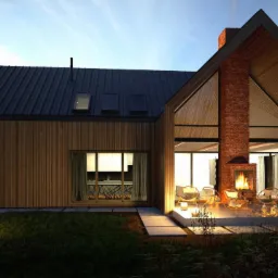 Wizualizacja domu jednorodzinnego w Suwałkach z drewnianą elewacją, dużym oknem z widokiem na wnętrze i zewnętrznym kominkiem z palącym się ogniem, oświetlona lampami ogrodowymi o zmierzchu.