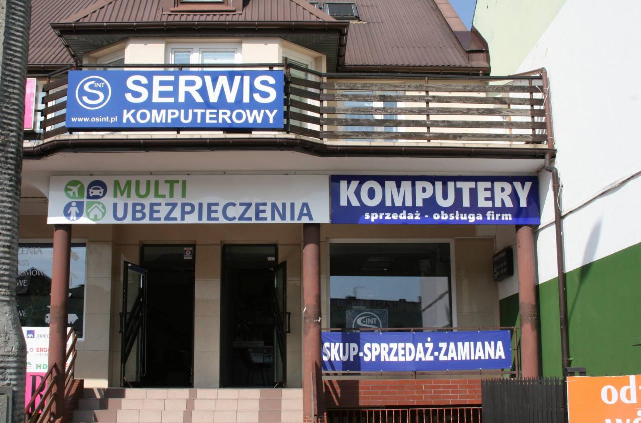 Fasada budynku z szyldami: 'Serwis Komputerowy', 'Multi Ubezpieczenia', 'Komputery sprzedaż - obsługa firm' i 'Skup-Sprzedaż-Zamiana'.