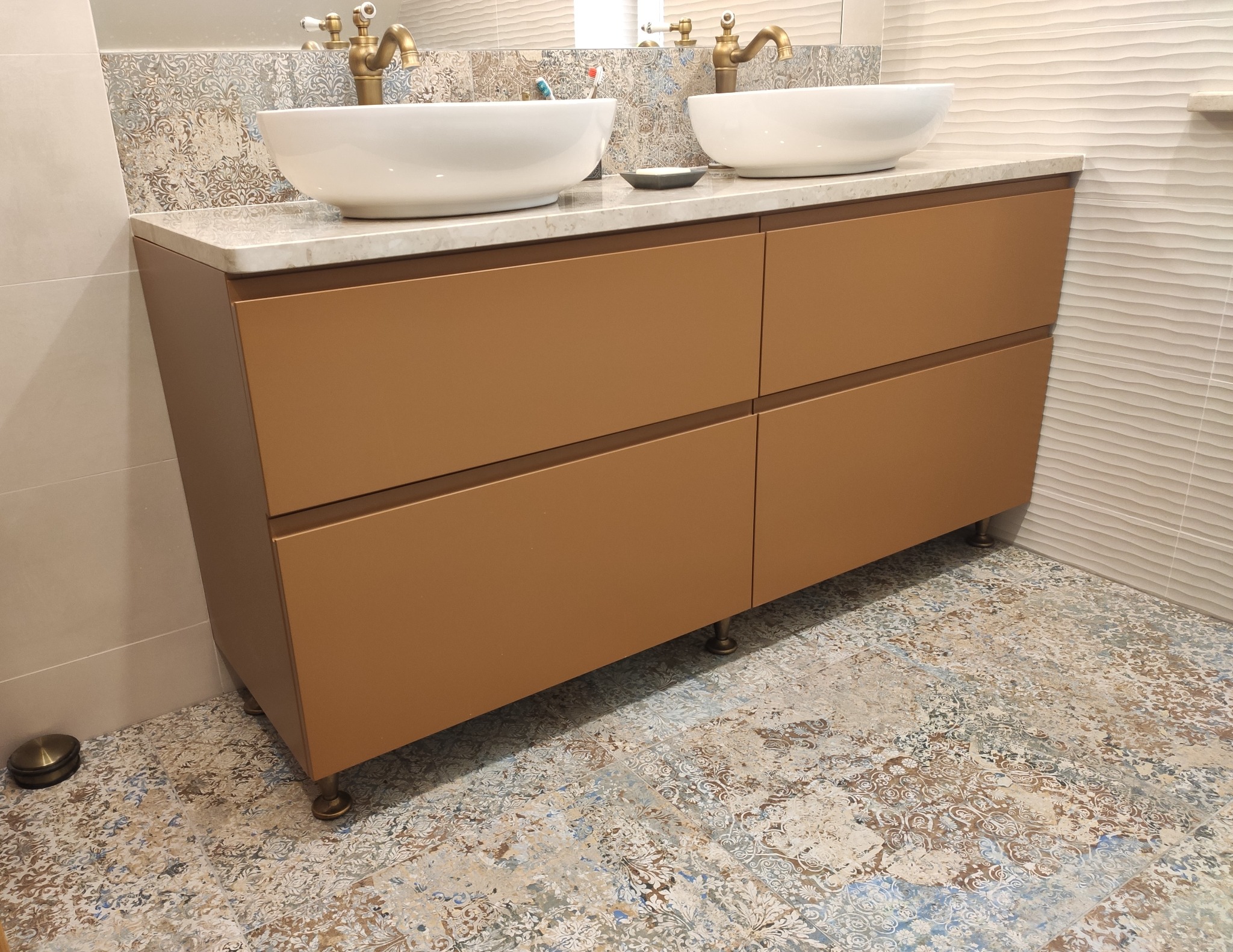 Łazienkowa szafka pod umywalki nablatowe z czterema szufladami, w kolorze ciepłego brązu, na niskich złotych nóżkach, z blatem z jasnego kamienia, Łódź.