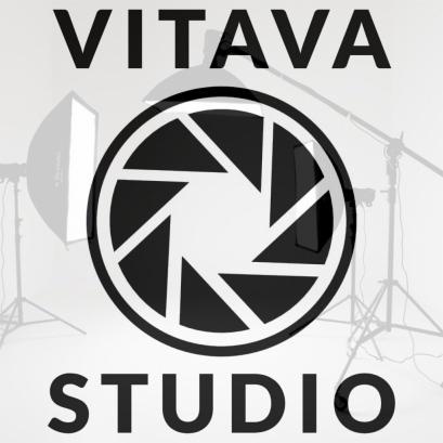 Logo Vitava Studio z motywem przysłony na tle sprzętu oświetleniowego.