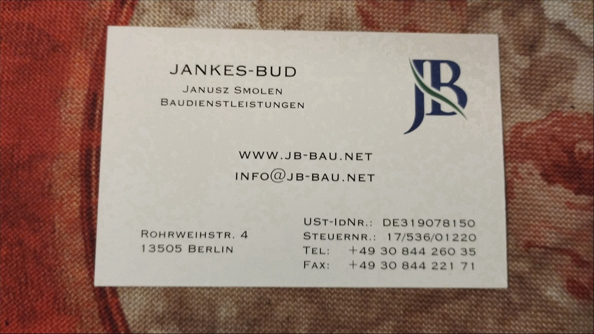 Wizytówka firmy Jankes-Bud Janusz Smolen Baudienstleistungen z adresem w Berlinie, numerem telefonu i adresem e-mail, na wzorzystym tle.